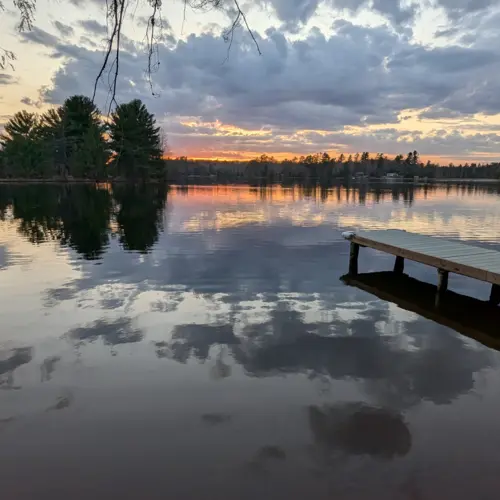 Boating on the crystal clear lakes of Eagle River, WI, with direct water access from our private dock at Smile Awhile.